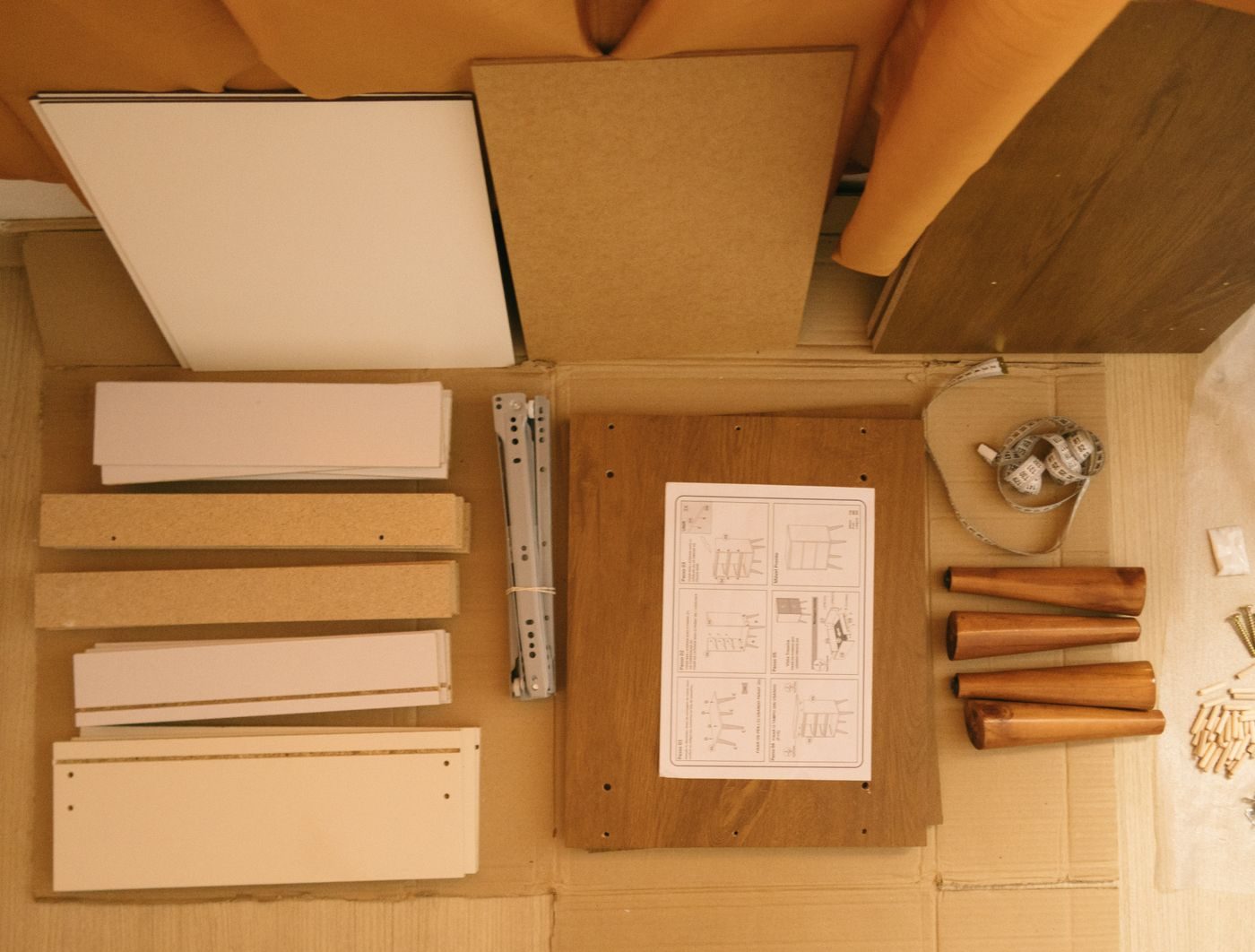 A wardrobe taken apart: panels, fittings and the instruction sheet laid out