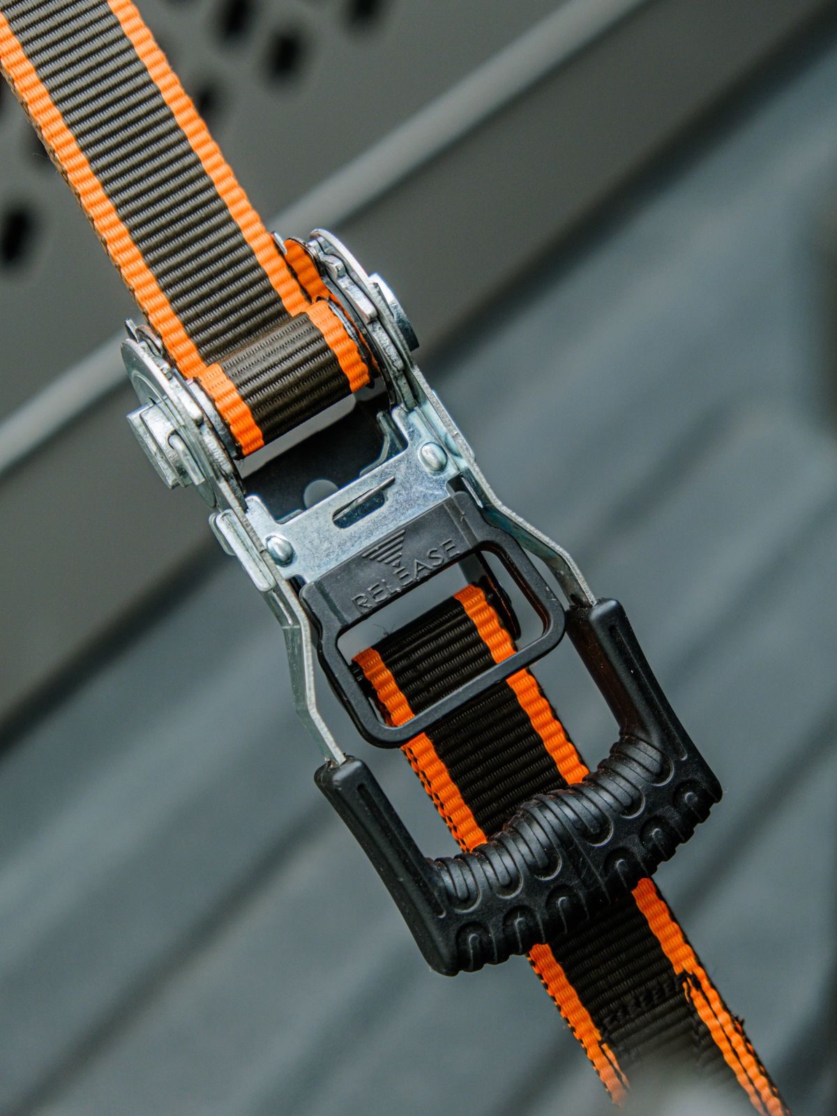 Close-up of a ratchet strap tensioned over cargo