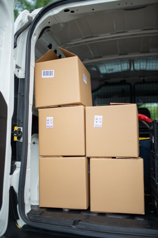 Cardboard boxes stacked in even columns in the back of a van